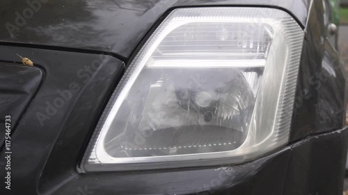 Close-up of a black car's front halogen headlight