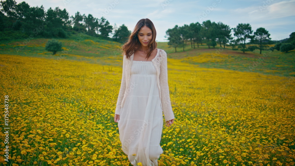 Brunette enjoy walk meadow at summer. Girl strolling at yellow flowers field Brunette enjoy walk meadow at summer. Girl strolling at yellow flowers field