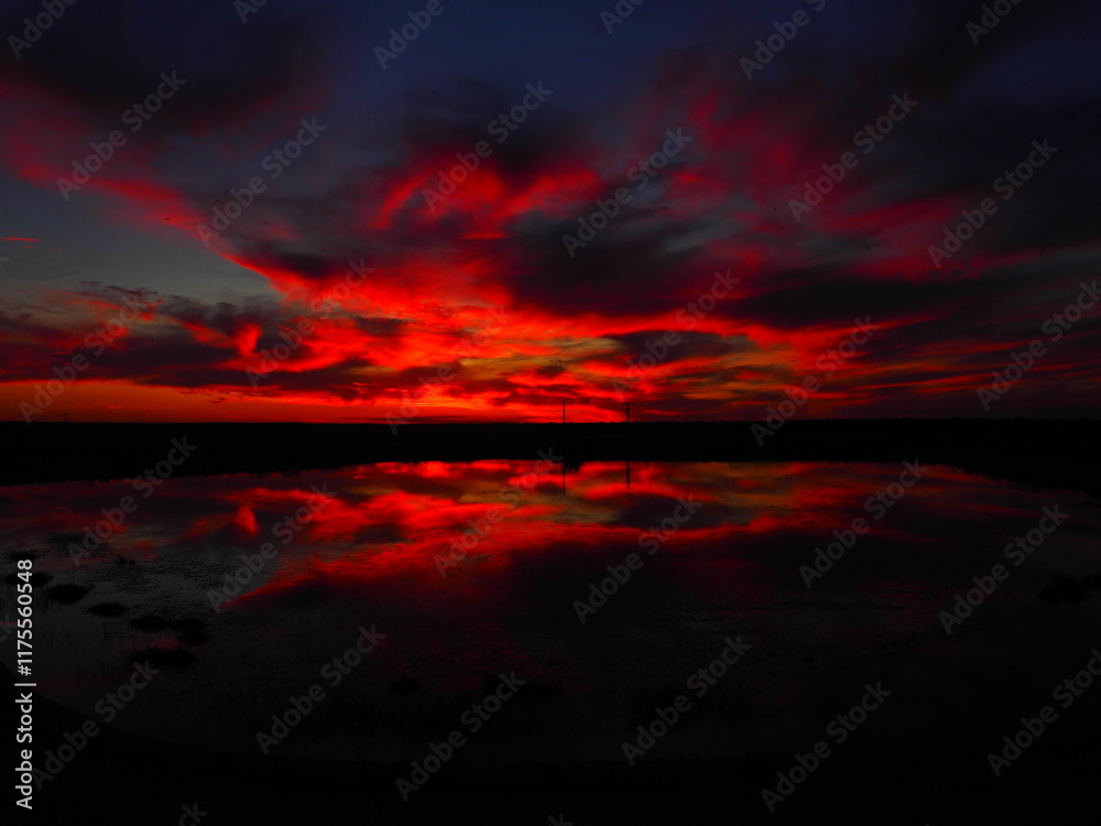 Fototapeta premium Reddish summer sunset over a lake in northern Spain