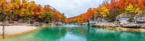 Tranquil Autumn Landscape Featuring Vibrant Fall Foliage Reflected in Calm River Waters Surrounded by Scenic Rock Formations and Lush Trees photo