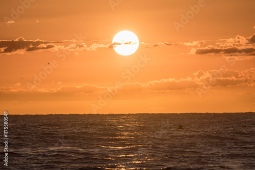 Yellow sun light reflecting on turbulent ocean surface, El Nino concept