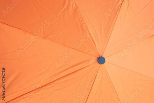 Black plastic cap on top of orange umbrella