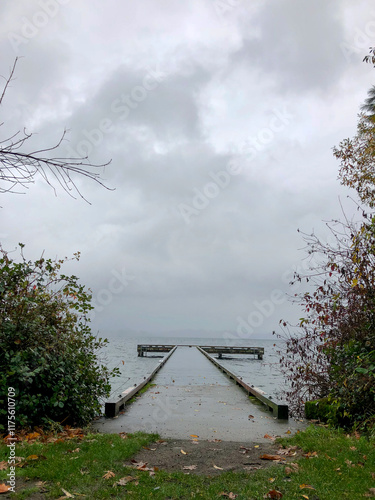Moody Dock Extends Into Stormy Lake Under Overcast Sky With Dense Clouds