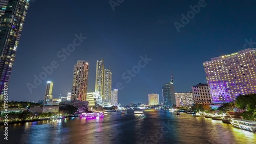 Time-lapse of beautiful lights of water public transport, and boat traffic on the Chao Phraya River with condominium buildings. Hotels at night in Bangkok, Thailand's capital