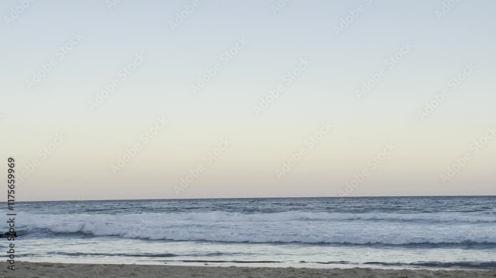 Tranquil scene featuring sea waves with clear sky at sunset, and a bird flied by in distance Tranquil scene featuring sea waves with clear sky at sunset, and a bird flied by in distance