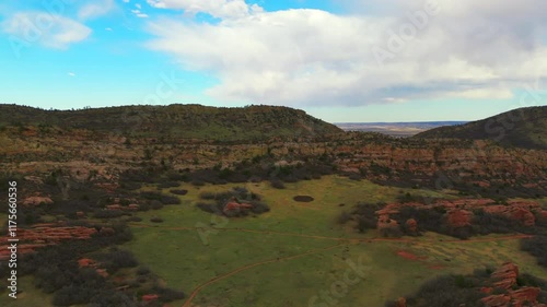 view of the red rocks of Colorado in grassy land with hills in Ken Caryl Valley under cloudy sky photo