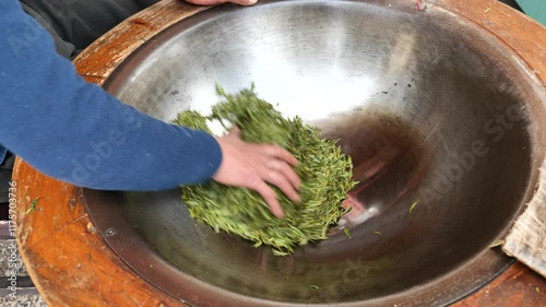 The process of making longjing green tea by hands, rubbing tea leaves in the wok, Hangzhou China. High quality 4k footage photo