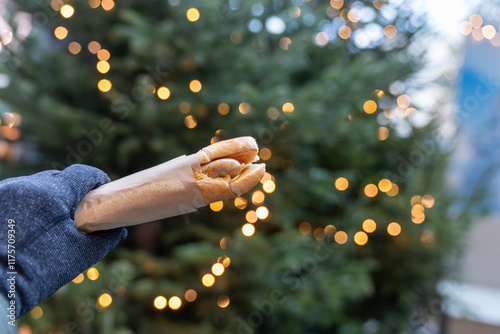 Hand holds a bosna hot dog sausage from a Salzurg Austria Christmas market