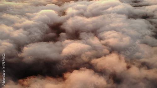 Golden morning sunlight streaming through a dense sea of clouds, creating a captivating aerial view of fluffy cloud formations and soft atmospheric hues.