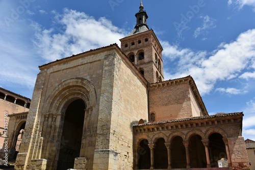Massive Romanesque stone structure of St. Martin church, Segovia, Spain, incl Mudejar bell tower, porticoed gallery and a huge portal plus door framed by five archivolts and Old Testament sculptures