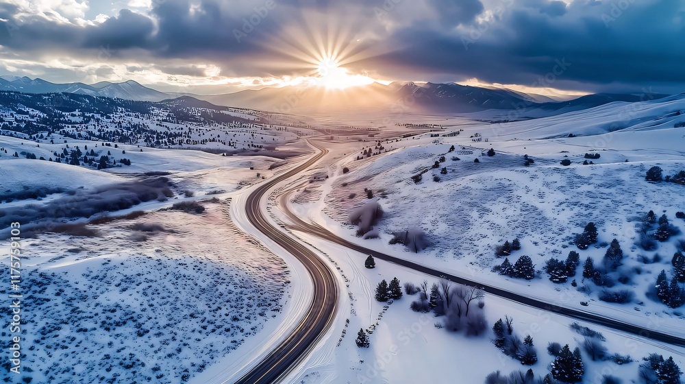 Aerial view of a snow-covered highway winding through a mountain valley at sunset. Aerial view of a snow-covered highway winding through a mountain valley at sunset.