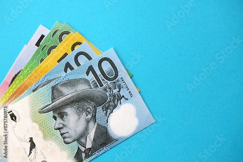 Few modern Australian dollar bills in different denominations lies on blue background photo