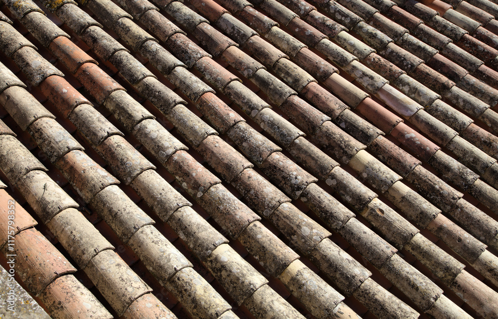 Weathered clay roof tiles showing pattern and texture in sunny outdoor setting during daytime Weathered clay roof tiles showing pattern and texture in sunny outdoor setting during daytime