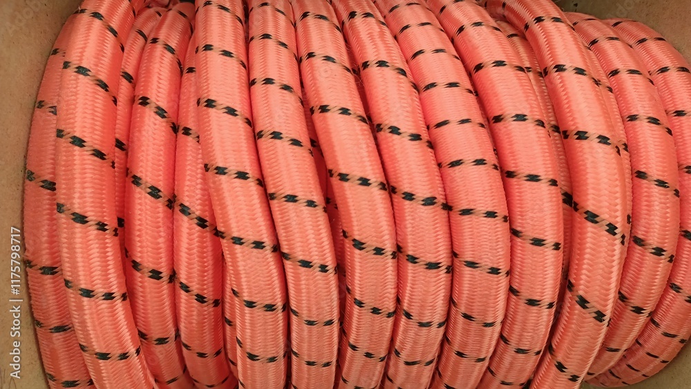 A coiled pink rope that features decorative black dots, perfect for a variety of uses A coiled pink rope that features decorative black dots, perfect for a variety of uses