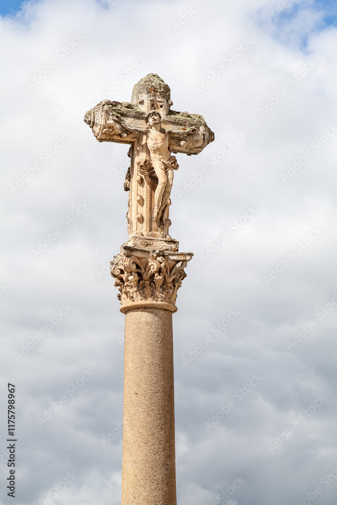 Historical crucifix on a column against a cloudy sky in Salamanca, Spain during the day Historical crucifix on a column against a cloudy sky in Salamanca, Spain during the day