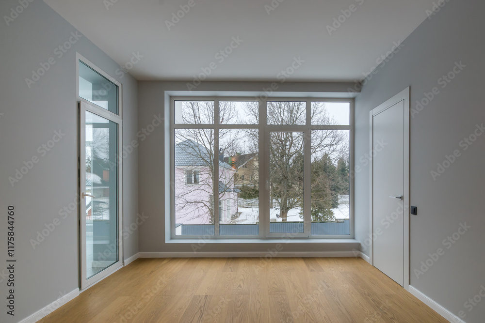 Fototapeta premium A room with a final finish, unfurnished, in a country house. Glass door, panoramic window with a view of the winter landscape.