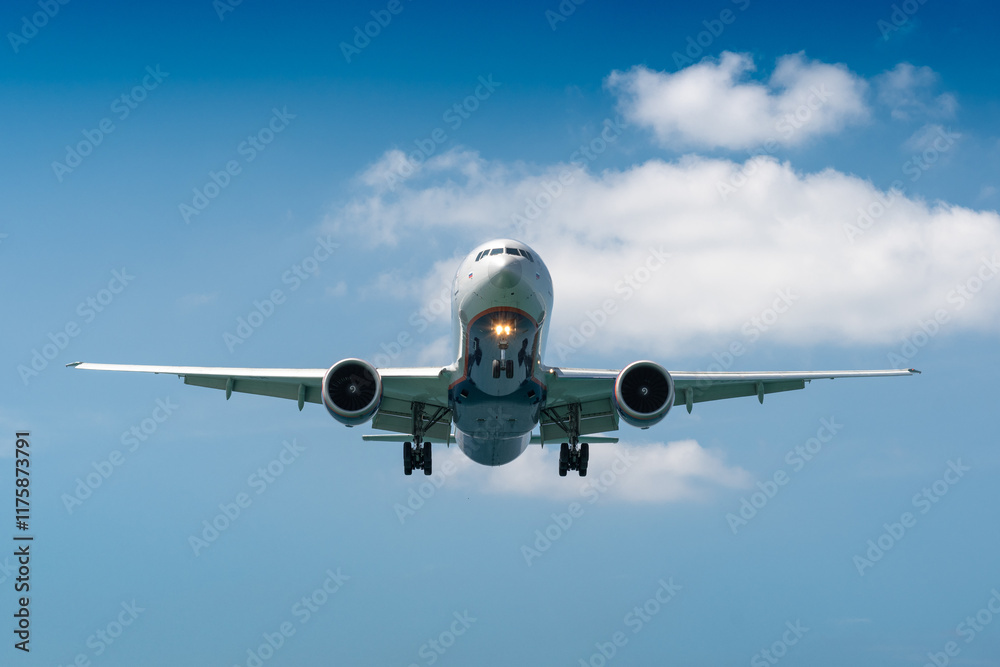 A blue sky background with an airplane prepared for landing on a well known place for plane spotter at Mao Khao Beach, Phuket, Thailand A blue sky background with an airplane prepared for landing on a well known place for plane spotter at Mao Khao Beach, Phuket, Thailand