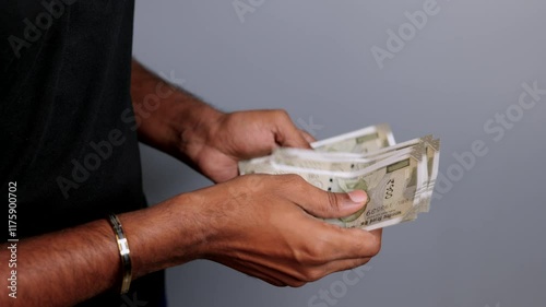 Counting indian five hundrend rupees note in black tshirt