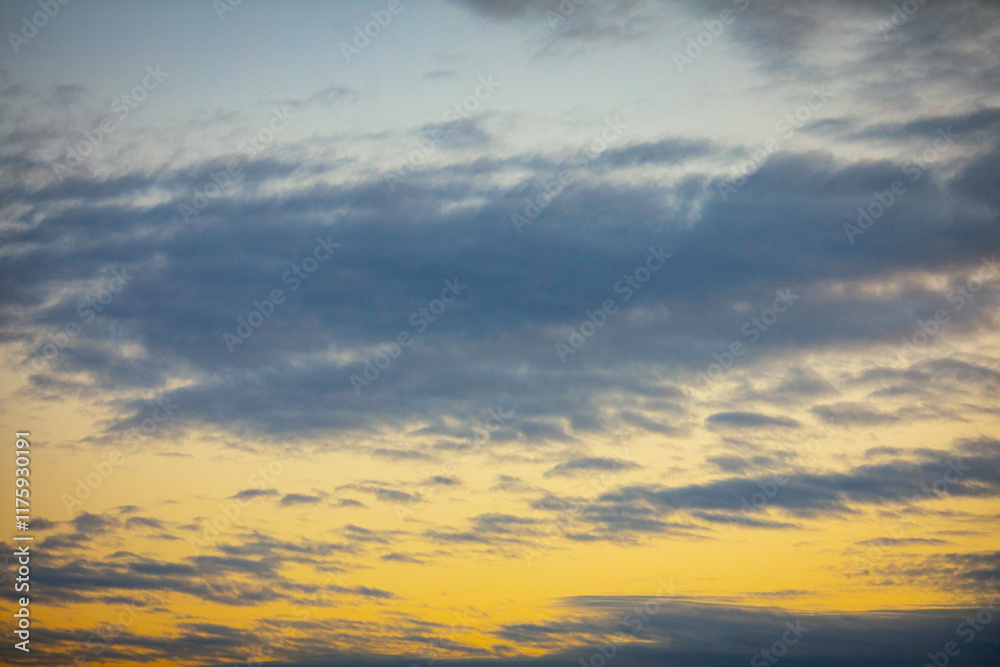 The peaceful and serene atmosphere of a cloudy sky at dusk is filled with warm hues of color The peaceful and serene atmosphere of a cloudy sky at dusk is filled with warm hues of color