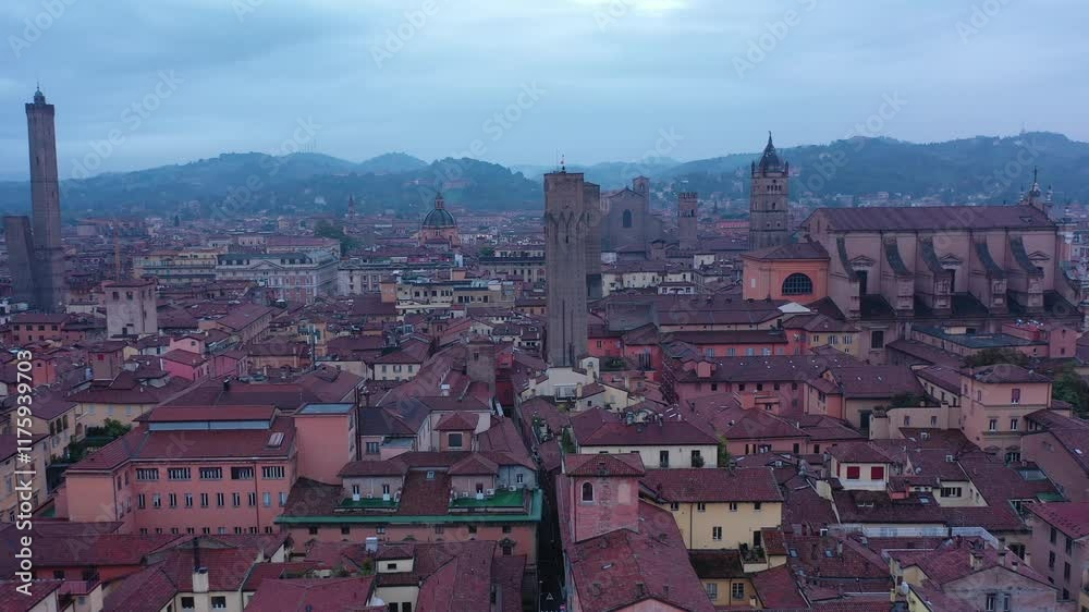 Aerial view of Torre Garisenda and Torre degli Asinelli at evening in Bologna, Italy. The towers stand tall over the red rooftops, glowing in the twilight and highlighting the city’s charm. Aerial view of Torre Garisenda and Torre degli Asinelli at evening in Bologna, Italy. The towers stand tall over the red rooftops, glowing in the twilight and highlighting the city’s charm.