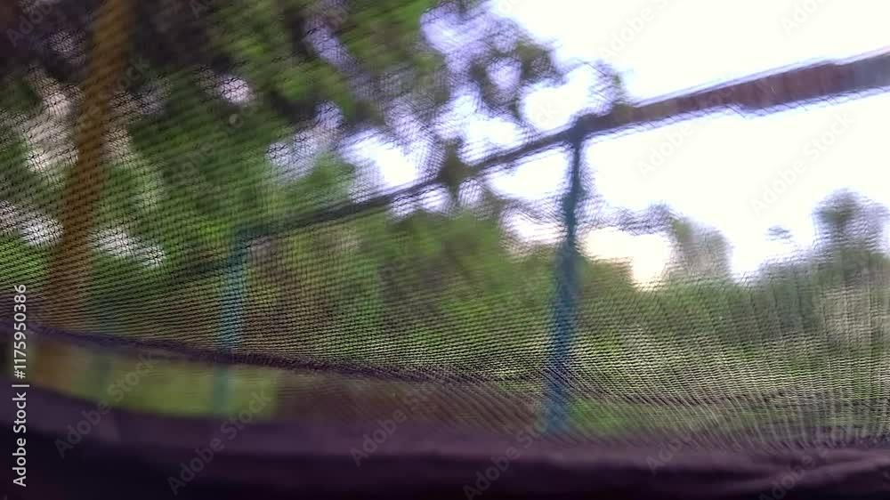 Trampoline safety Net on a busy outdoor Playground, with flying Mosquitoes outside