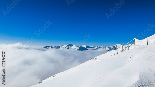 Panorama of the winter peaks of the Tatras from Kasprowy Wierch. A sunny, winter December day. The mountain peaks are covered in thick clouds.