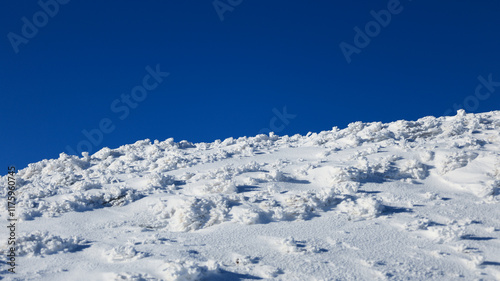 Panorama of the winter peaks of the Tatras from Kasprowy Wierch. A sunny, winter December day. The mountain peaks are covered in thick clouds.