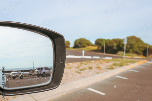 car parked at the coast with view in rear vision side mirror