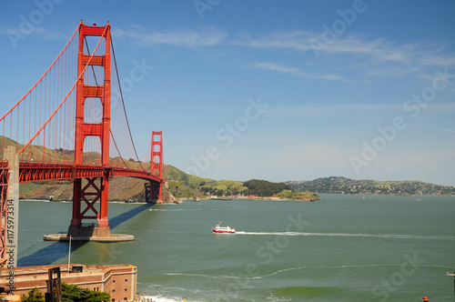 Golden Gate Bridge over San Francisco Bay with hills and boat below photo