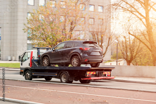 Tow Truck Transporting Disabled SUV With Engine Malfunction On Flatbed photo