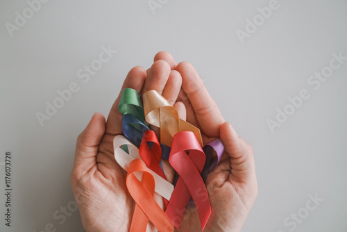 Hands holding color ribbons, world cancer day, World Autism Awareness Day concept