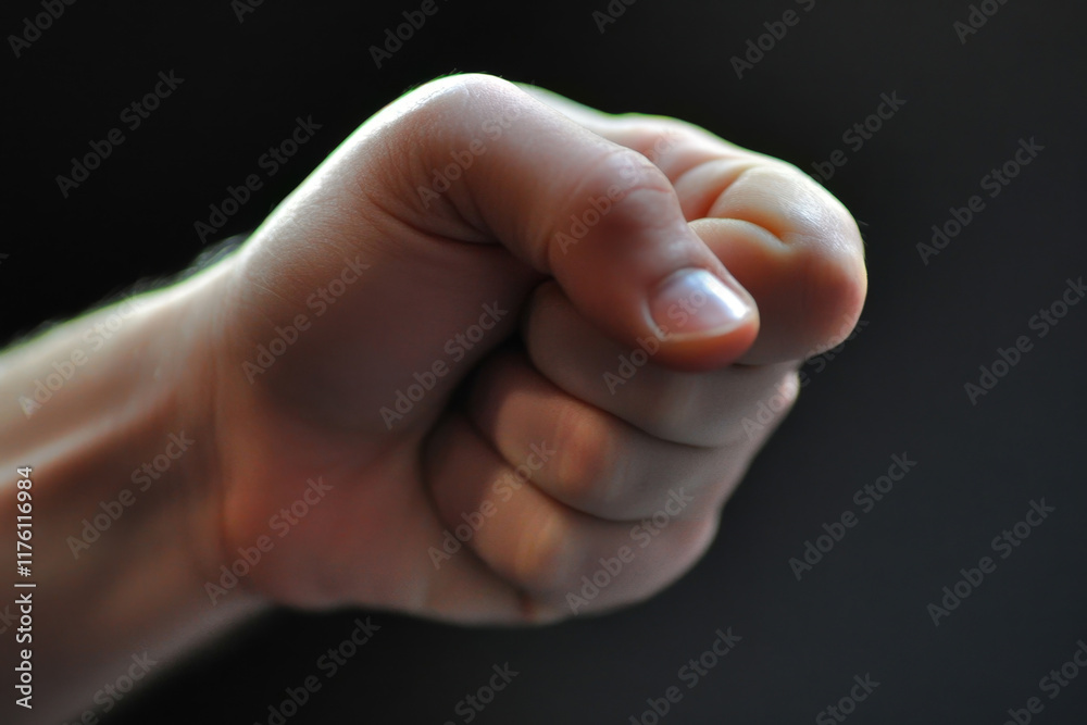 Fist clenched tightly with defined knuckles hoping for strength and determination captured in expressive gesture during a moment of focus and intensity Fist clenched tightly with defined knuckles hoping for strength and determination captured in expressive gesture during a moment of focus and intensity
