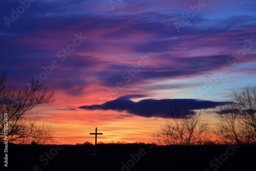 Beautiful sunset with colorful sky and cross silhouette in rural landscape