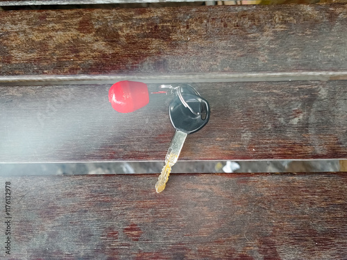 a key with a red wooden keychain on a bench with a natural smoke effect photo