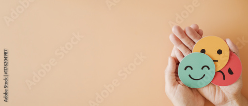 Hands holding sad face hiding behind happy face, bipolar and depression, mental health, split personality, mood change concept
 photo