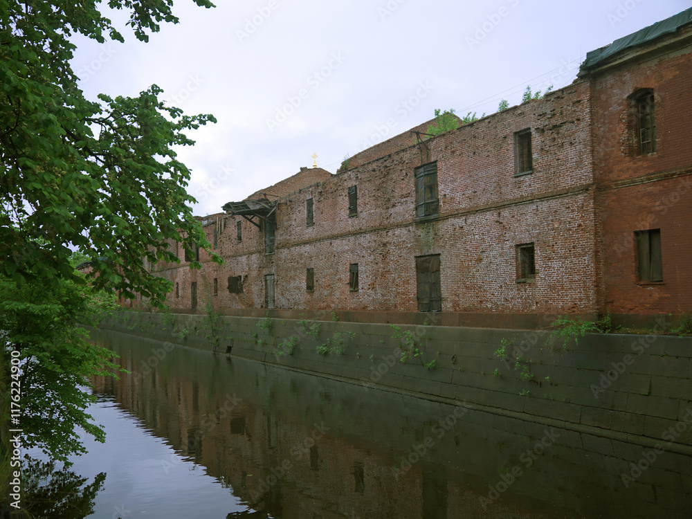 Long red brick wall and moat canal with water in Kronstadt fortress Long red brick wall and moat canal with water in Kronstadt fortress