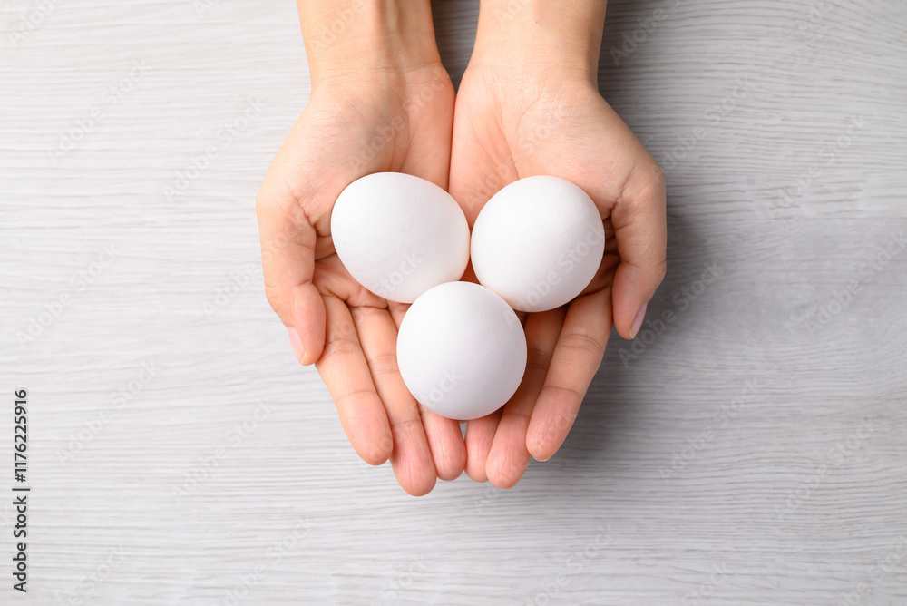 White eggs holding by hand on white background, Table top view White eggs holding by hand on white background, Table top view