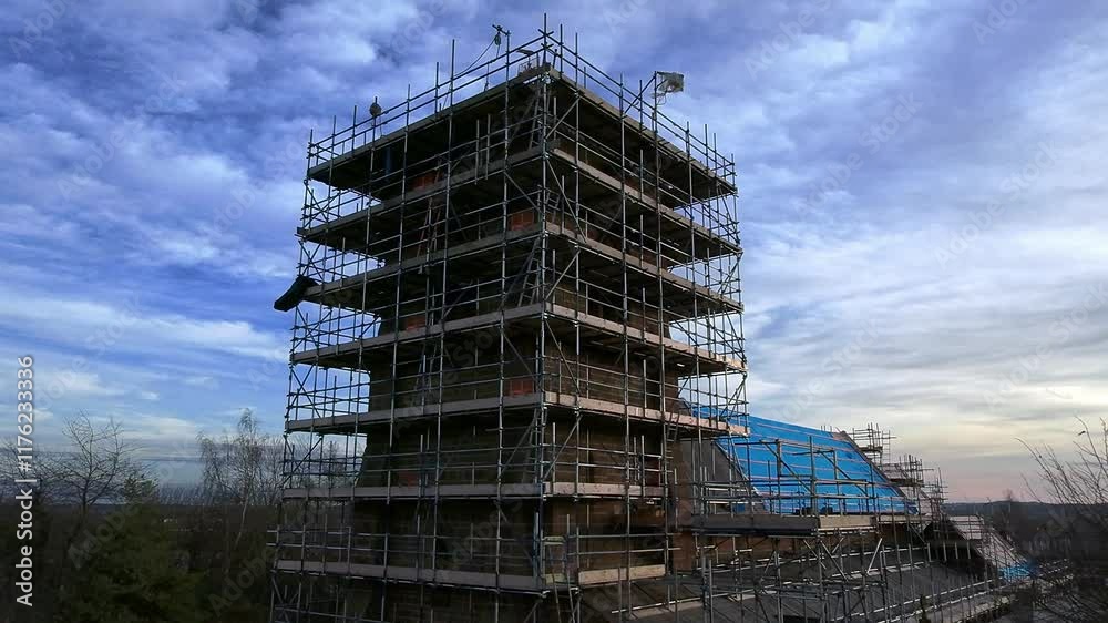 Church tower scaffolding aerial view circling complex building site framework at sunset