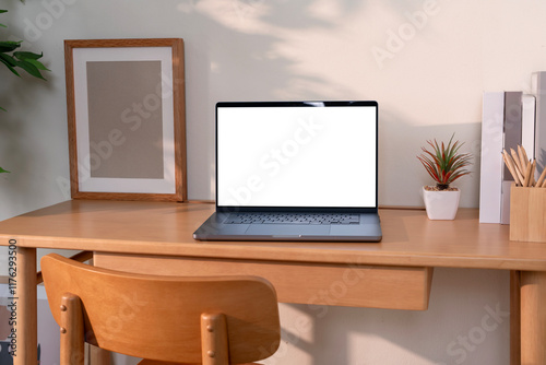 Laptop with blank white screen on wooden desk, home office, work from home.