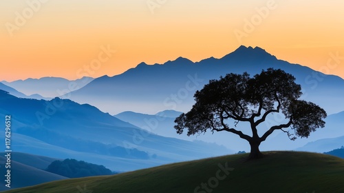 A serene silhouette of a lone tree against a stunning sunset backdrop, with majestic mountains in the distance, creating a tranquil and picturesque landscape scene. photo