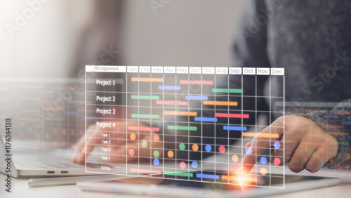 Konstfotografi A project manager working on laptop and updating tasks and milestones progress planning with a Gantt chart scheduling interface for the company on a virtual screen