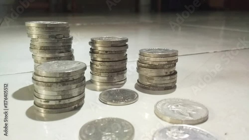 A woman's hands stack and count Indonesian rupiah coins