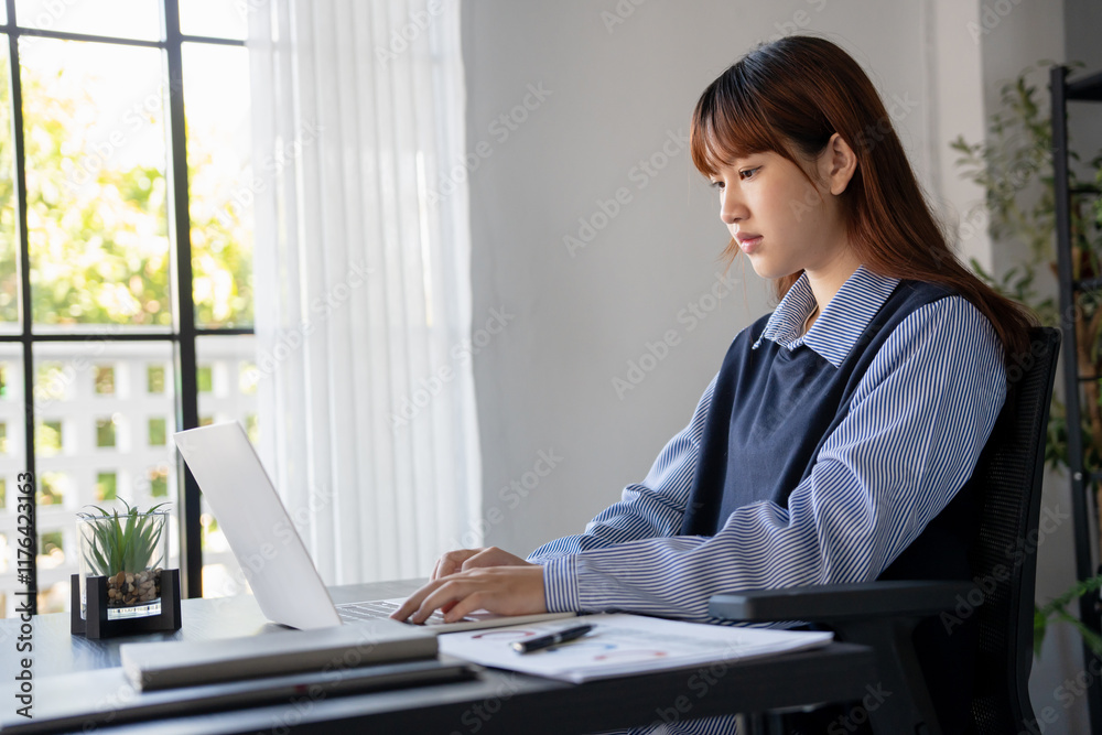 Asian businesswoman using laptop doing documents Asian businesswoman using laptop doing documents