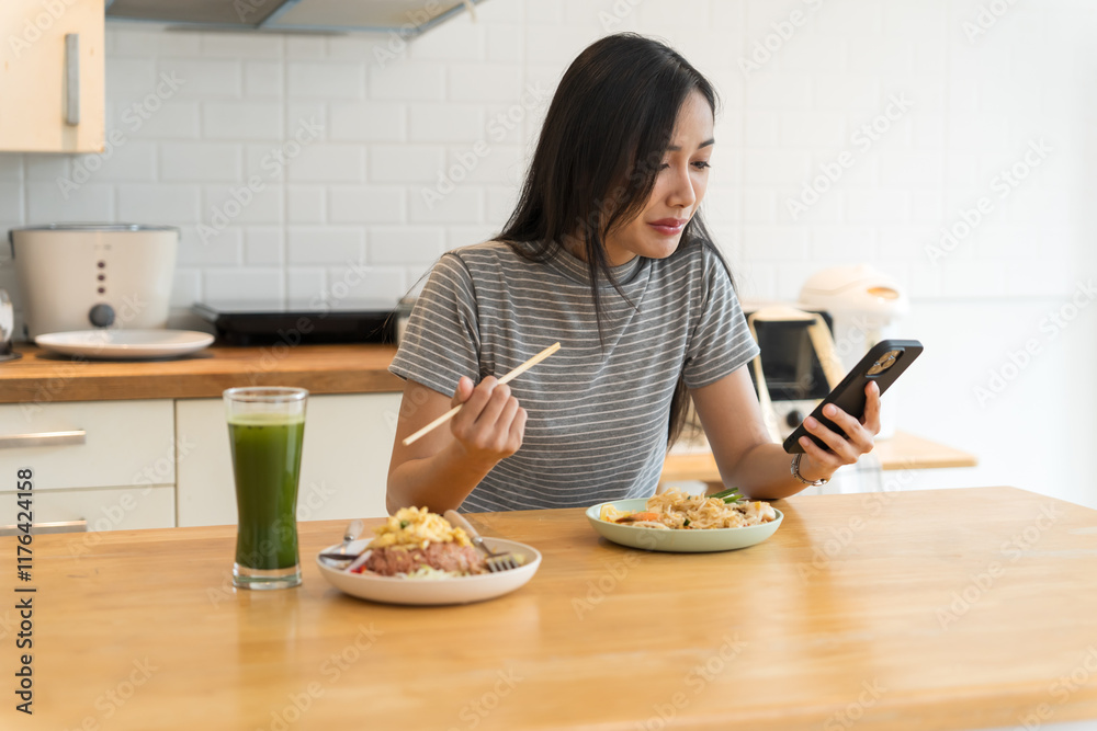 Asian Girl eating Thai food in kitchen counter Home delivery food feeling happy Asian Girl eating Thai food in kitchen counter Home delivery food feeling happy