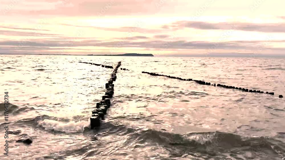 cross groynes on the Baltic Sea beach on Rügen at sunset