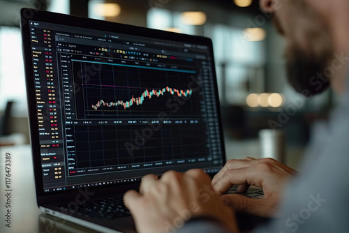 Portfolio manager reviewing stock performance on a laptop in a modern office setting photo