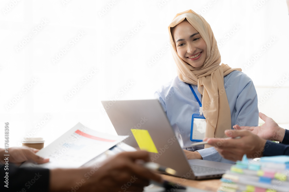 Collaborative Discussion: A young woman wearing a hijab engages in a lively discussion with colleagues, showcasing their diverse team dynamics and collaborative approach to problem-solving. Collaborative Discussion: A young woman wearing a hijab engages in a lively discussion with colleagues, showcasing their diverse team dynamics and collaborative approach to problem-solving.