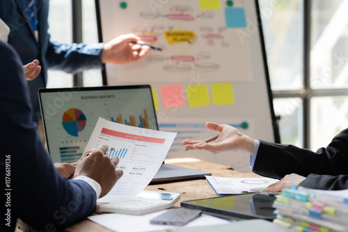 Strategic Business Meeting:  A diverse team collaborates around a table, reviewing data and engaging in a lively discussion.  The image depicts a modern business setting. photo