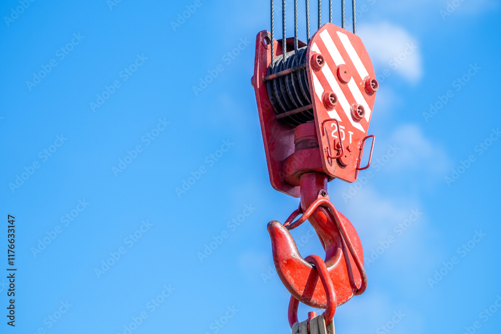 Red industrial crane hook against clear blue sky. Red industrial crane hook against clear blue sky.
