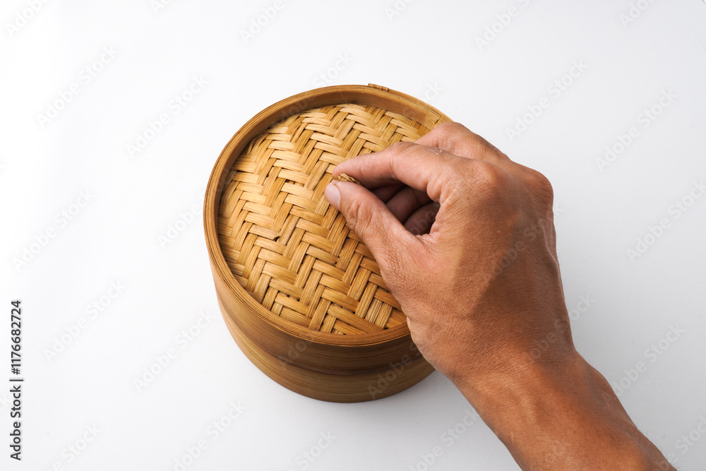 Fototapeta premium Close-up photo of Someone hand is opening wooden dimsum steamer container isolated on white background. Shot on 30 Degree, flat lay angle setup